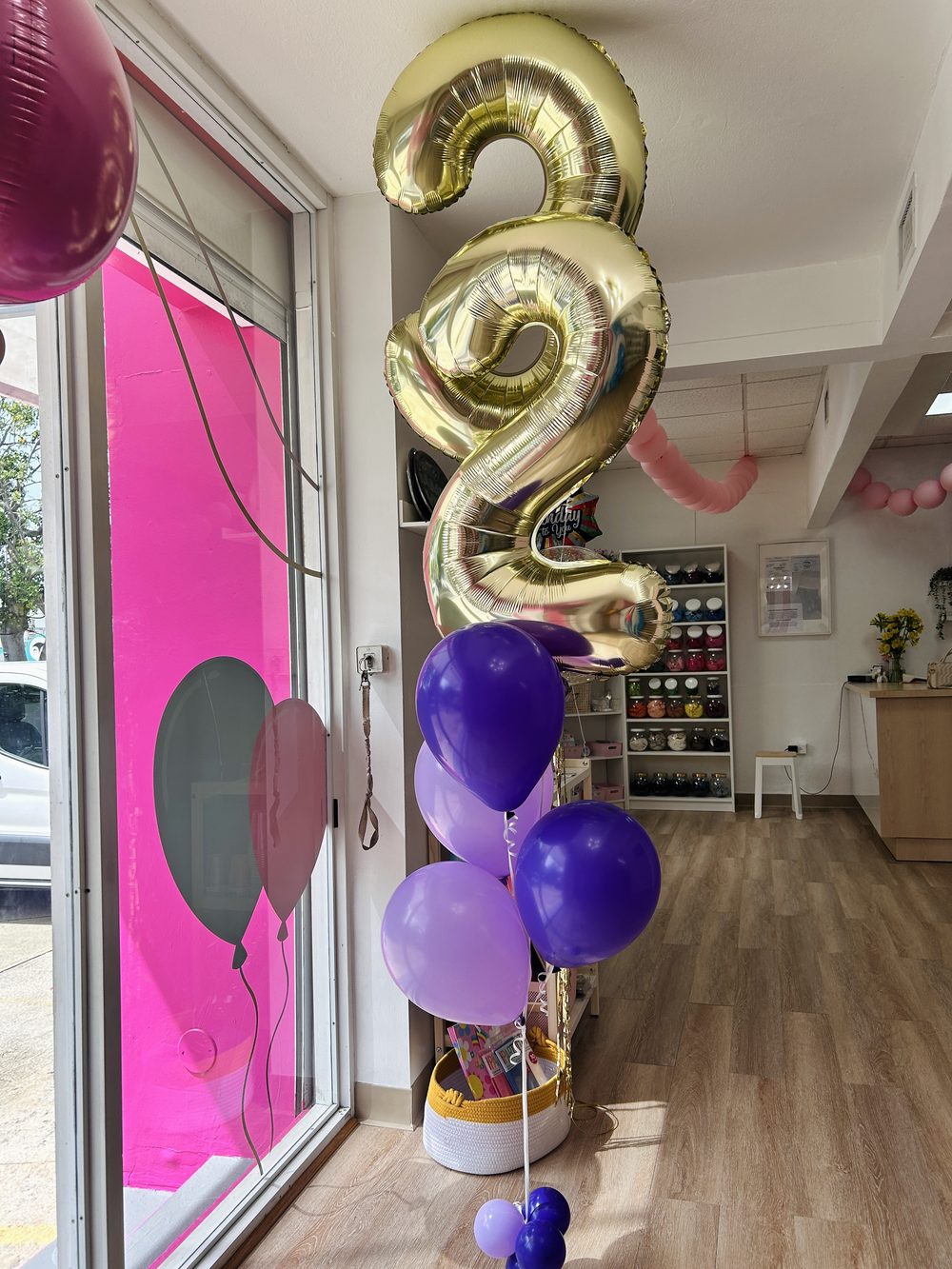 Globo dorado número 2 con globos morados dentro de la tienda