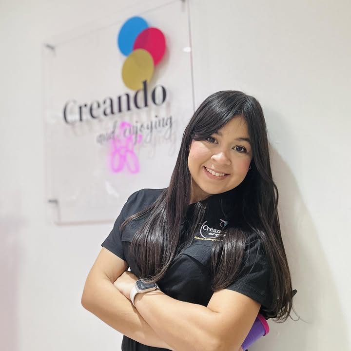 Marisol, de Creando and Enjoying, frente al logo de la tienda